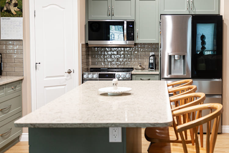 Sage-Green-Kitchen-Cabinets-With-Island-Seating-And-French-Door-Refrigerator Kitchen Renovation by Atom Builder