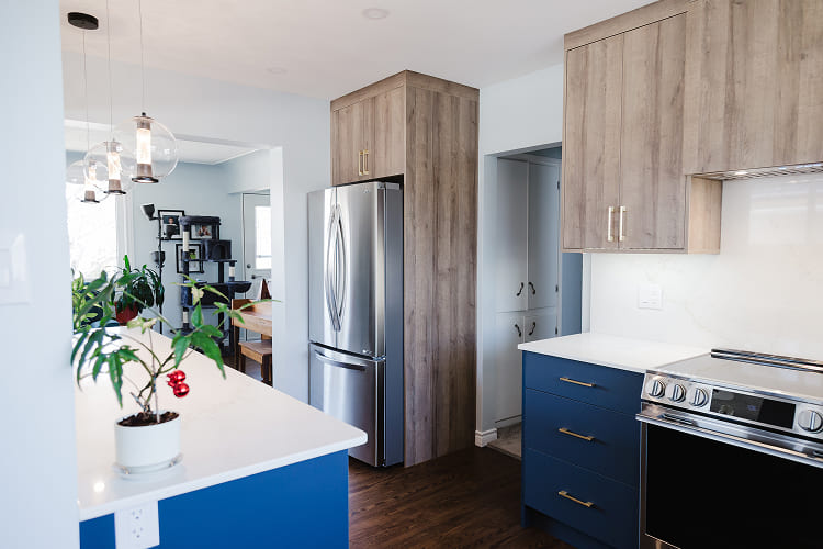 Modern-Kitchen-With-Blue-Island-And-Wood-Grain-Upper-Cabinets Kitchen Renovation by Atom Builder
